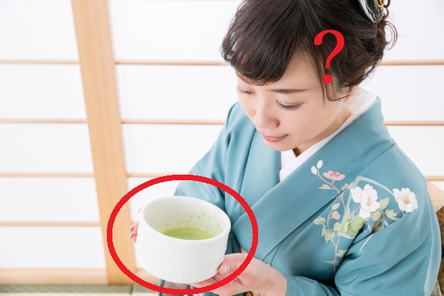 客が抹茶碗の正面がわからないまま茶を飲む画像